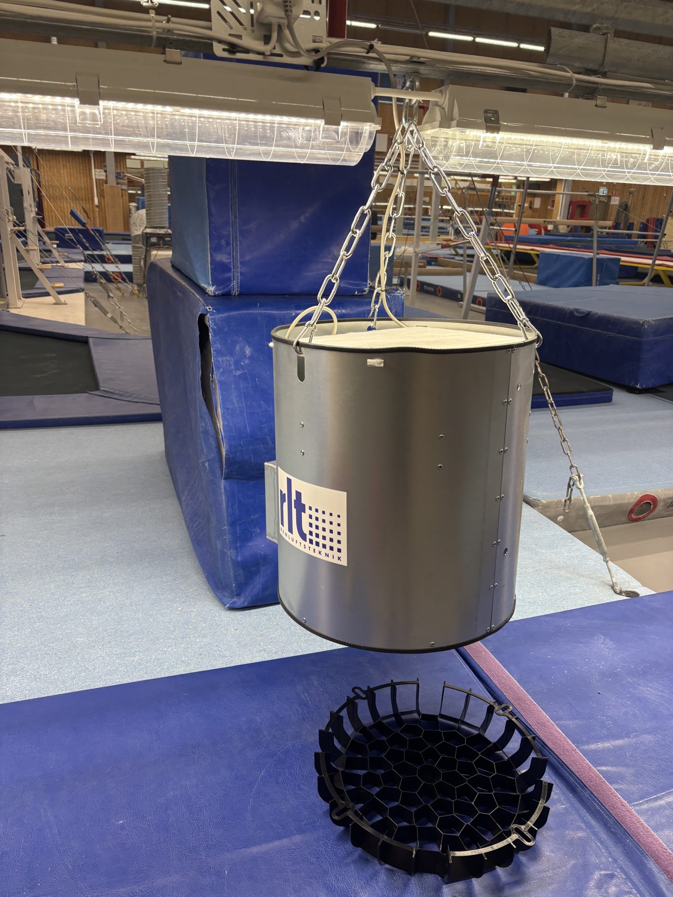En OxyVent Ceiling hänger i kedjor i taket i en idrottshall